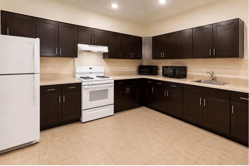 Full kitchen with gas range, refrigerator, microwaves, and cabinet storage