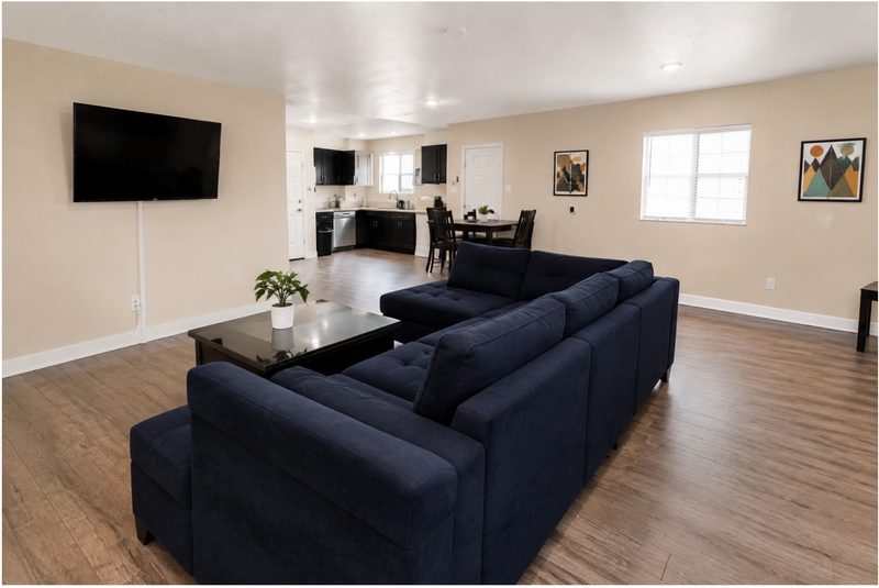 Living room at 1442 with sectional seating opening onto the kitchen and dining table