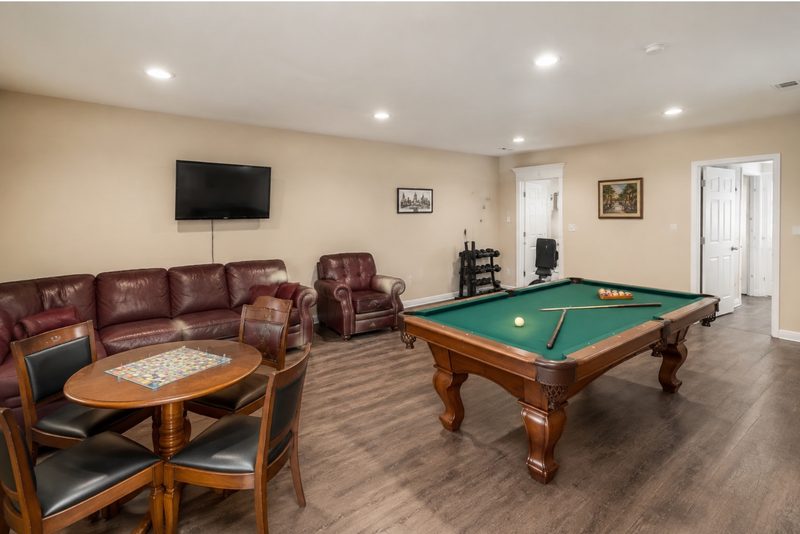 Recreation room with pool table, game table, seating, and a television